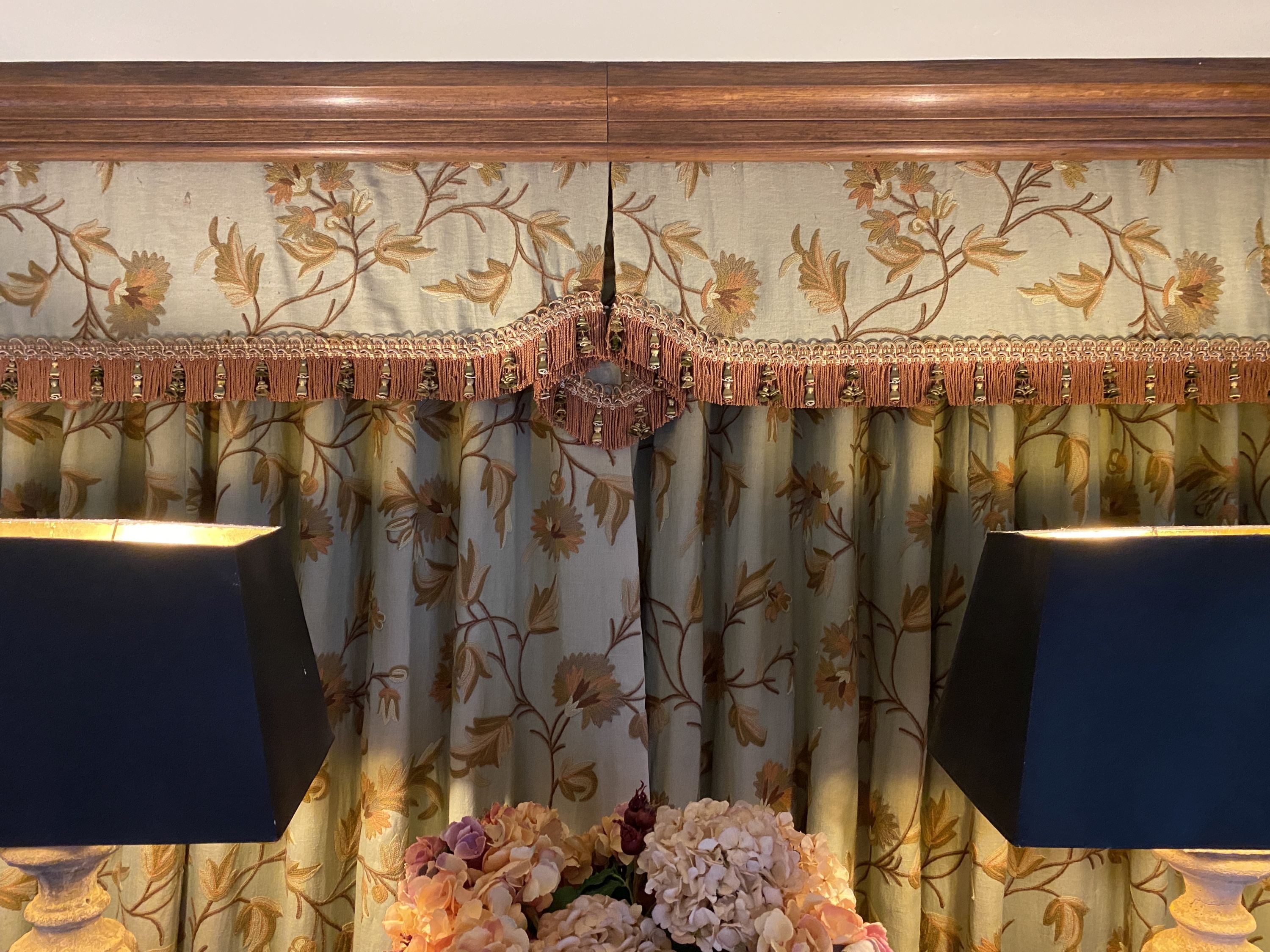 A pair of eau de nil linen curtains with floral crewel work decoration, and matching two piece pelmet, drop 230cm, generously made to fit an aperture of 3.6m